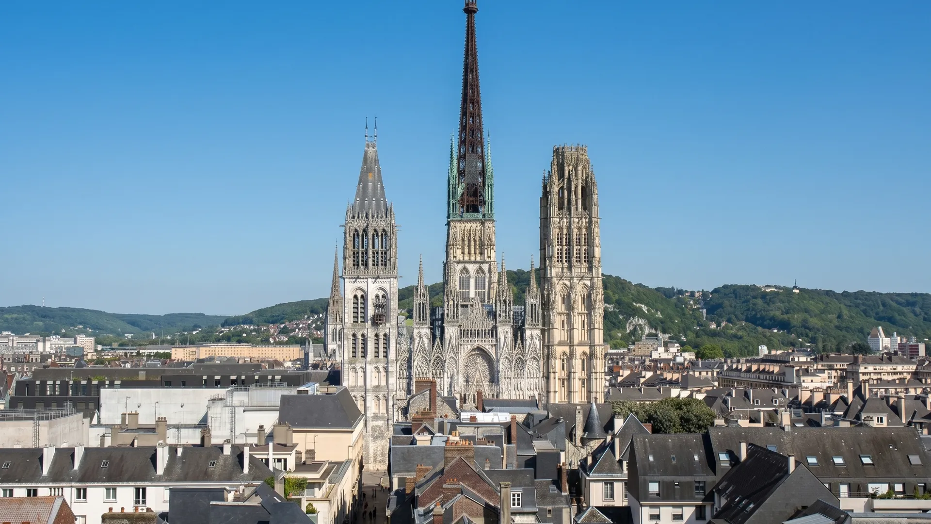 Couvreur sur toit ardoise à Rouen, avec la cathédrale Notre-Dame en arrière-plan
